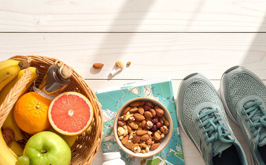 Fresh fruit, nuts, and walking shoes flat lay representing balanced nutrition and gentle daily movement
